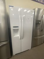 White LG side-by-side refrigerator with water/ice dispenser on the left door; a 'Sale Price' sign is taped to the front.