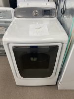 White front-loading washing machine with a starburst sale sign on the top lid of the unit.