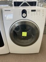 Samsung front-loading washing machine on display with a yellow sticky note on the door handle area