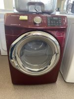 Maroon Samsung front-loading washing machine with a yellow sticky note on the control panel.