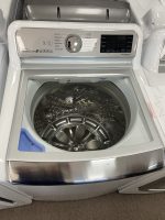 Front-loading washing machine with door open, stainless steel drum visible inside.