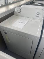 White Amana top-load washing machine with a paper sale price tag reading 'SALE PRICE $295' resting on the lid.