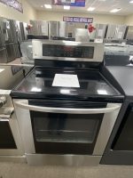 Stainless steel LG freestanding oven in a showroom, with other refrigerators in the background and a sale tag on the range door