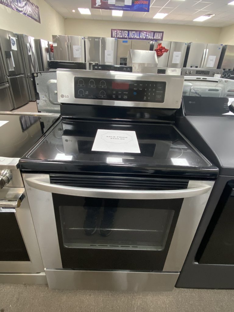 Stainless steel LG freestanding oven in a showroom, with other refrigerators in the background and a sale tag on the range door