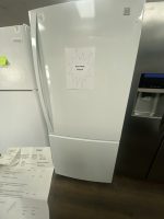 White refrigerator with a 'SALE PRICE $350.00' sign taped to the door in a store display.