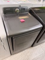 Samsung front-loading Samsung washing machine in a showroom with a pink sticky note on the lid