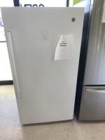 White upright refrigerator with a taped sale price tag showing $595 in a showroom.