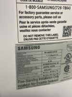 Close-up of a Samsung appliance label with model RF260BEAESG/AA, serial number, and warranty text in English and French