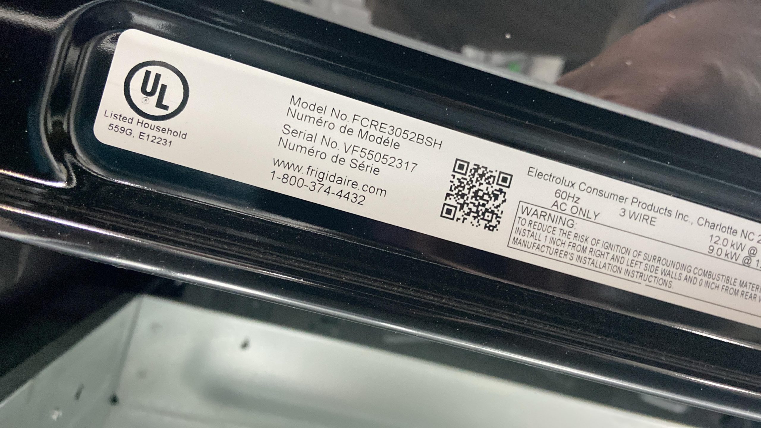 UL-listed appliance label on a dark surface including model FCRE3052BSH, serial VF5052317, QR code, and Frigidaire contact info (www.frigidaire.com, 1-800-374-4432).