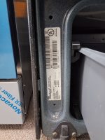 Whirlpool appliance label with barcode and model/serial numbers on a dark metal frame.