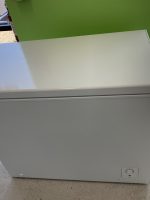 White Hisense chest freezer with the lid closed in a store display area, logo visible on the front.