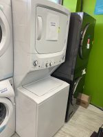 Front-loading washing machine on display with a sale price tag of $795 in a showroom lineup of appliances on a green wall.