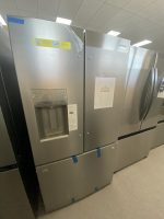 Stainless steel Frigidaire fridge on a showroom wall with a sale price poster showing $1,400.00.