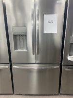 Stainless steel, side-by-side refrigerator with an external water/ice dispenser on the left door and a sale sign ($950) taped to the right door.