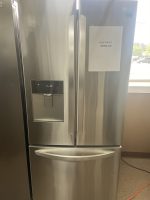 Stainless steel LG side-by-side refrigerator with ice dispenser; sale sign on right door shows 'SALE PRICE $950.00'