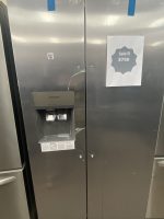 Stainless steel side-by-side refrigerator with water dispenser on the left; a sale sign reading 'Sale!!! $760' taped to the right door.