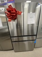 Stainless steel double-door refrigerator with a large red gift bow on the left door and a price notice on the right door.