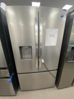 Stainless steel side-by-side Whirlpool refrigerator with water dispenser on the left door, price tag showing $1550 on the right door.