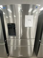 Stainless steel side-by-side refrigerator with a white sale sign reading 'SALE PRICE $2500.00' on the right door