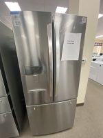 Stainless steel side-by-side refrigerator on display with a price sheet reading 'SALE PRICE $1325.00' on the right door.