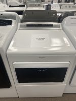 Whirlpool top-load washing machine in a showroom with a sale price sign reading $325.00 on the lid