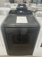 img_5135-4 - Discount Appliances Samsung top-loading washing machine in a showroom, with a sale-price paper placed on the lid.