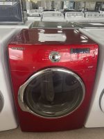 img_5288-2 - Discount Appliances Red Samsung front-loading washing machine in a showroom with other washers and dryers behind it, on sale.