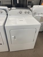 White Whirlpool top-load washing machine on sale, paper price tag showing $275.00 placed on the lid, showroom with other appliances in background