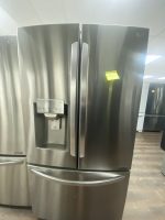 Stainless steel French-door refrigerator with a built-in water/ice dispenser on the left door.