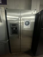 Stainless steel side-by-side refrigerator with water dispenser; sale sign reading "Sale!! $450" attached to the right door.