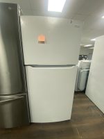 White Frigidaire refrigerator on display in a showroom, with a small pink sticky note on the door.