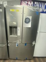 Stainless steel side-by-side refrigerator on sale with printed price tag and protective tape on doors in a showroom.