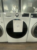 Front-loading washing machines in a showroom with a starburst sale sign reading ‘NEW SALE PRICE $850.00’ attached to the middle unit.