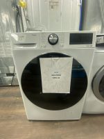 LG front-loading washing machine in a showroom with a starburst sign showing sale price $850.00.