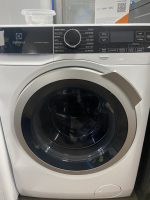 Front-loading Electrolux LuxCare Wash washing machine with a large circular door and black control panel above the drum.