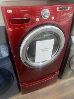 Red front-loading LG SteamDryer with a chrome drum door and a sale price tag reading $250.00 attached to the door area in a showroom.
