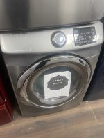 Samsung front-loading washing machine with control panel on the right and a sale tag on the door reading $295.00