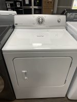 Front view of a white top-load washing machine with a large central dial and a small start button; a sale price tag reads $2255.00 on the lid surface in a showroom setting.