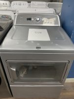 Front-loading Maytag washing machine with a sale price sheet reading $175.00 placed on the top edge of the drum lid in a showroom.