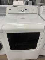 Front-loading washing machine with a sale tag on the lid showing $225.00. The control panel shows cycle options and settings in a showroom.