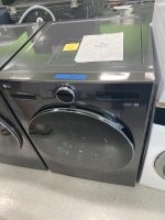 LG WashCombo front-loading washer and dryer in a showroom with a 'NEW SALE PRICE $2,100.00' sign on the top and blue tape reading 'New - combo' near the edge.