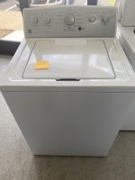 3fed4f7a-823e-47cf-b814-f6a928105c11-10075-0000034493a2e927_file - Discount Appliances Top-loading washing machine with closed lid and a sticky note on the lid reading 'colonial' in a laundromat setting.