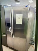 Stainless steel Whirlpool side-by-side refrigerator in a showroom with a sale sign listing $350 attached to the door