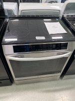5132dca1-e358-40f0-941b-bbcc36116cb0-37074-0000045c6ab104ed_file - Discount Appliances Stainless steel LG oven with a black glass induction cooktop in a showroom, price flyer nearby.