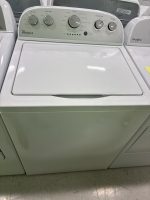 Whirlpool top-loading washing machine with control panel visible on the back, white and in a laundry setup