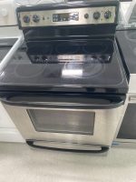 Stainless steel electric range with a black glass cooktop and control panel, four coil burners, and an oven door below.