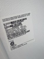 Close-up of a white appliance label with black text and a barcode, showing brand and installation/specification details (Electrolux).