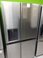Two stainless steel LG side-by-side refrigerators in a showroom; the left unit has a water/ice dispenser panel.