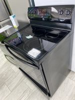 ccd85421-8b49-4c08-b743-d8df3743187b-34024-00000c7d6f5980da_file - Discount Appliances Black glass-top electric range with circular heating zones and a partially open lower drawer at the bottom.