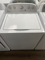White Whirlpool top-load washing machine with its lid open and circular control dials on the panel